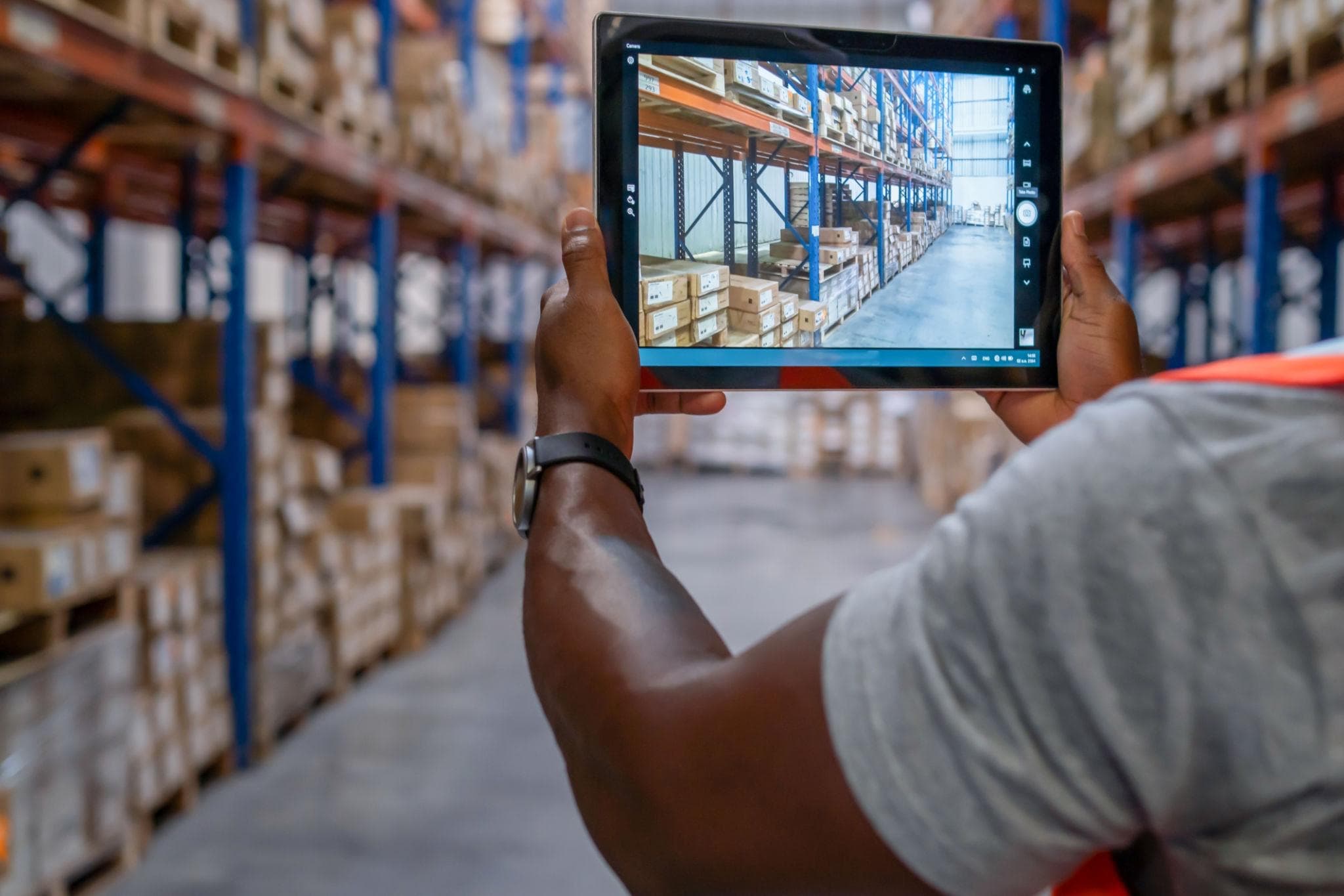 A warehouse manager checking stock levels on a tablet